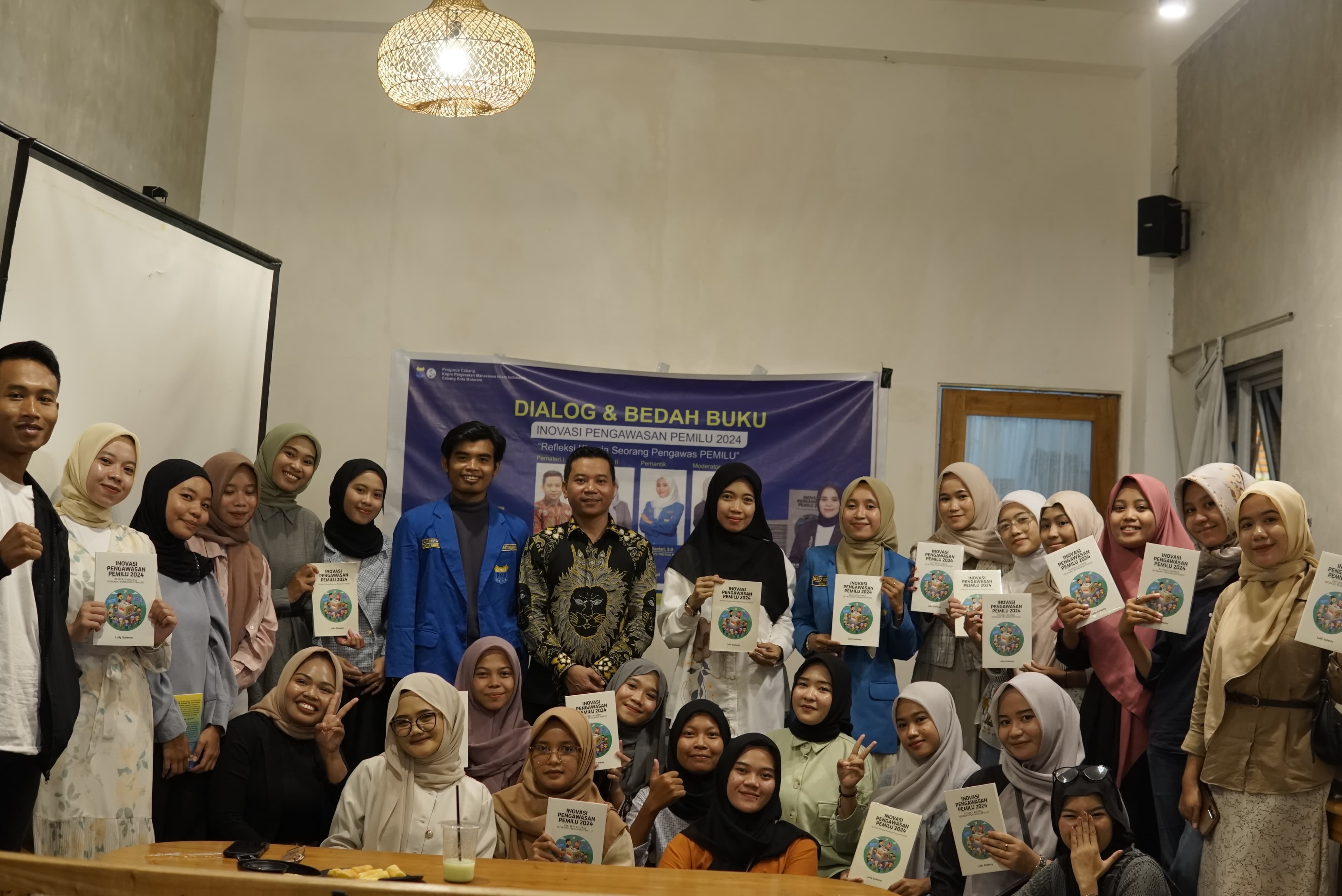 Samsul Hadi (Tengah Mengenakan Batik Lengan Panjang) Foto Bersama usai Kegiatan Bedah Buku 'Inovasi Pengawasan Pemilu 2024': Dorong Generasi Muda Aktif dalam Demokrasi. di Meiino Working Café, Gomong, Mataram, pada Senin, 20/01/2025.